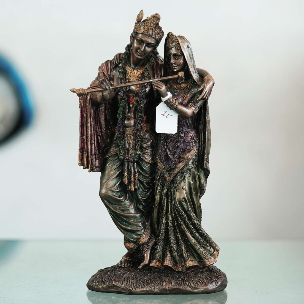 A beautiful and intricate bronze statue depicting Radha and Krishna, two central deities in Hinduism.